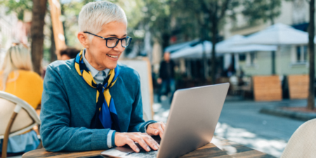 An employee working on her laptop outside.