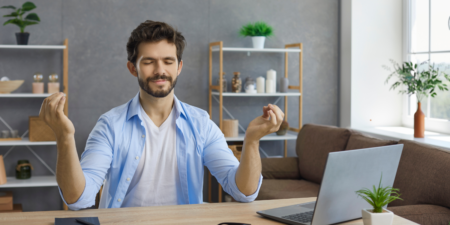 Employee taking a mindfulness moment in the workplace to meditate and realign his thoughts.